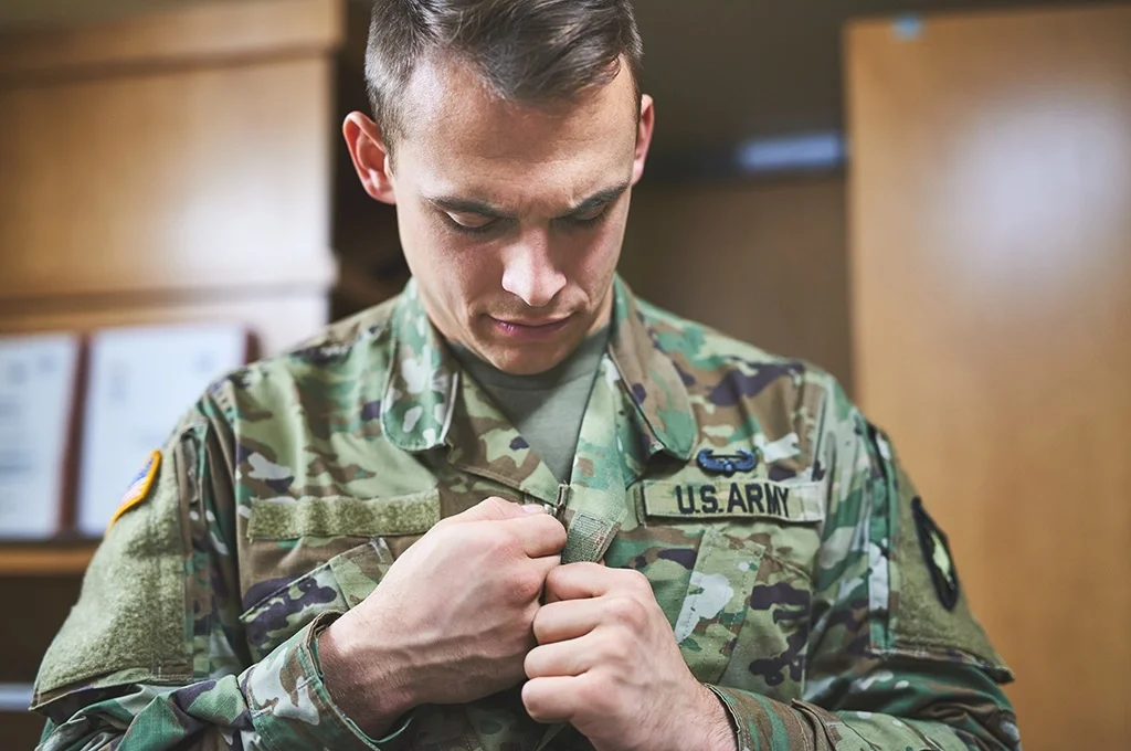 Army veteran zipping up his jacket