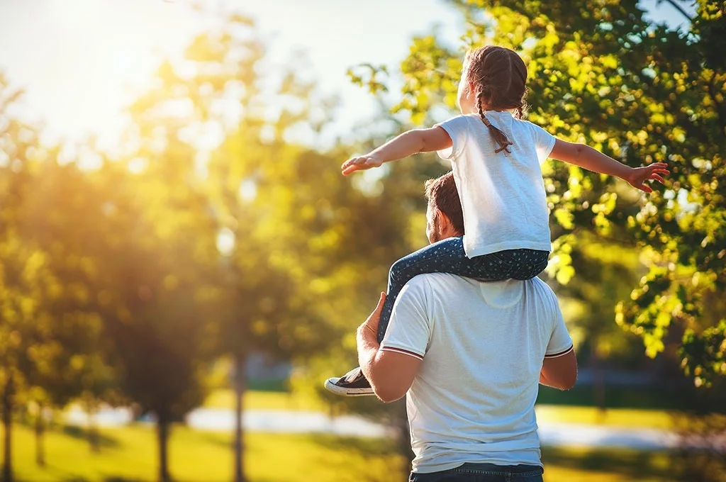 A veteran at the park with his daugther on his shoulders
