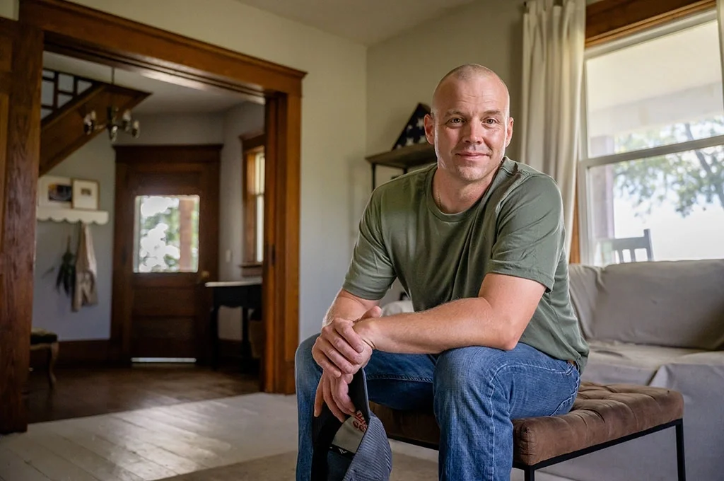 A marine veteran sits at home on his ottoman.