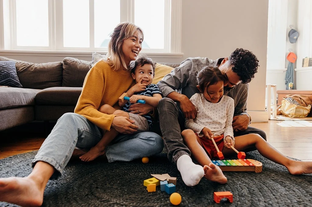A veteran poses with his family as they play together in the livingroom