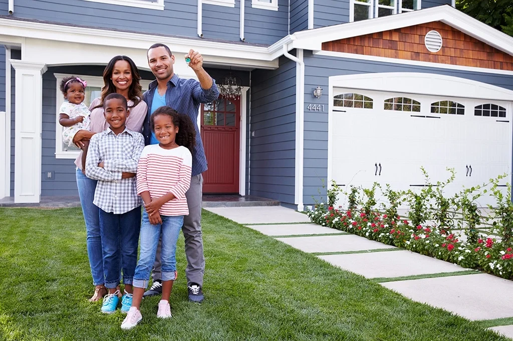 A veteran family stands outside of the home they purchased with their VA housing benefits eligibility