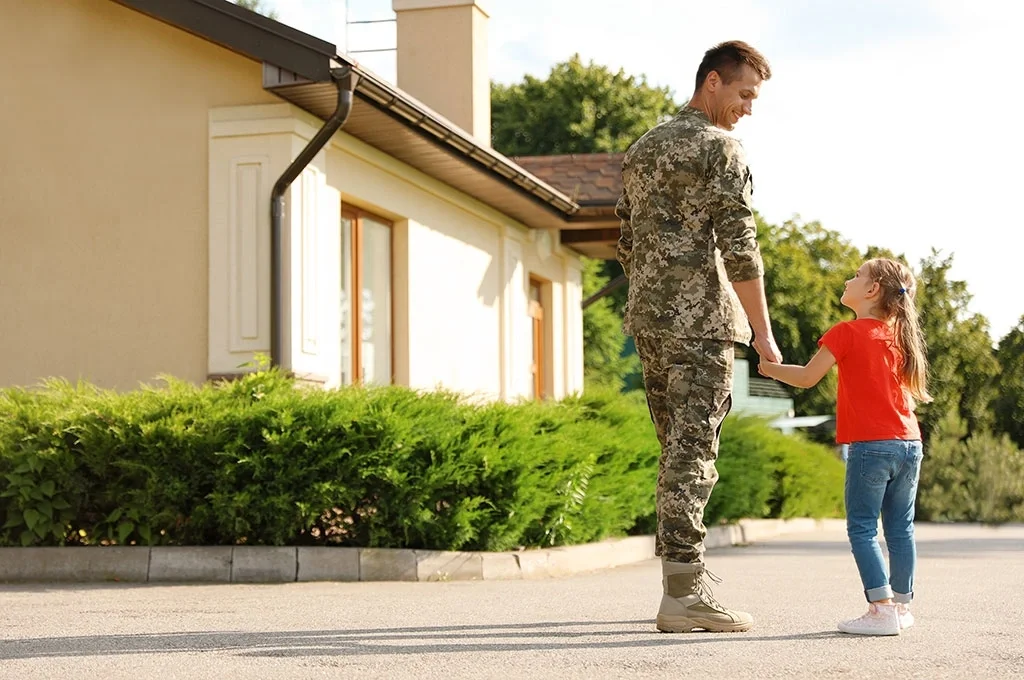 Veteran and his family posing in front of their home