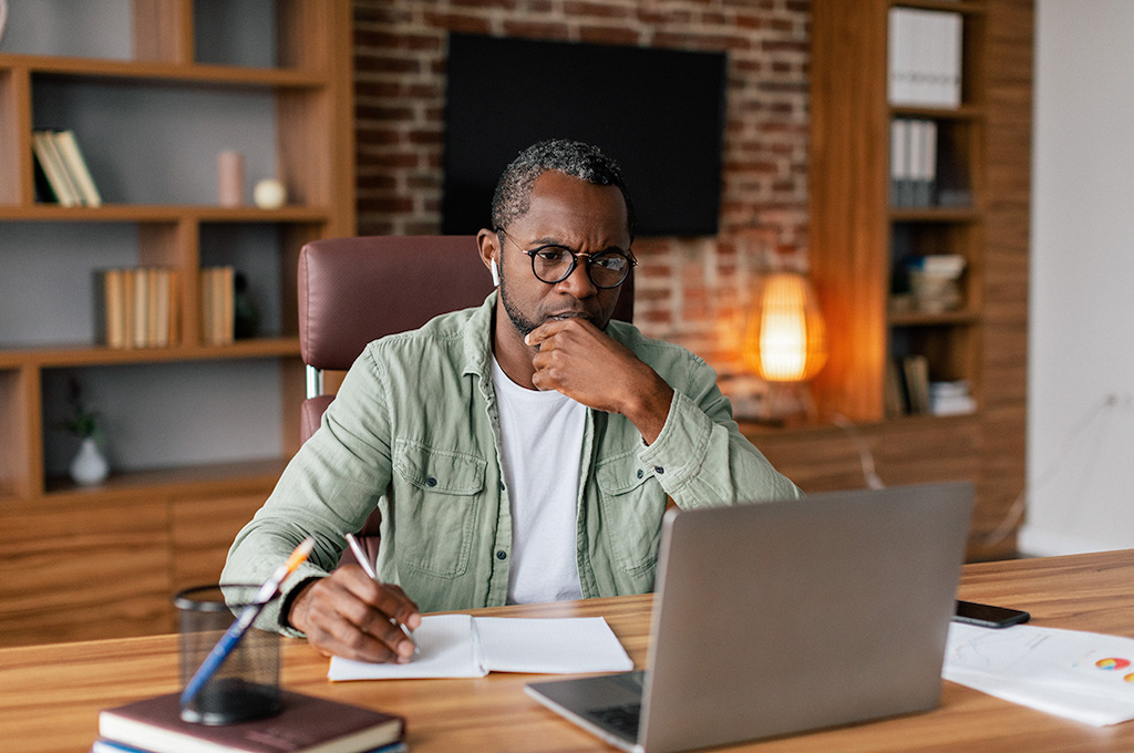 Veteran is sitting at his desk applying for benefits.