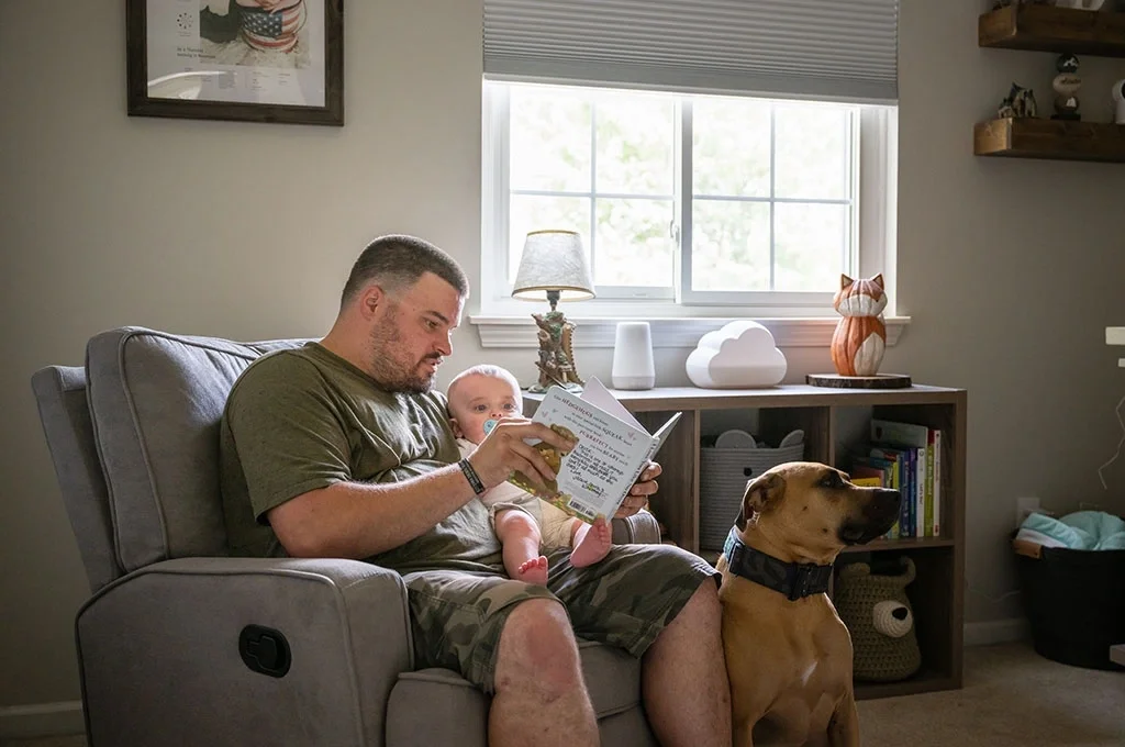 A veteran reads a book with his baby