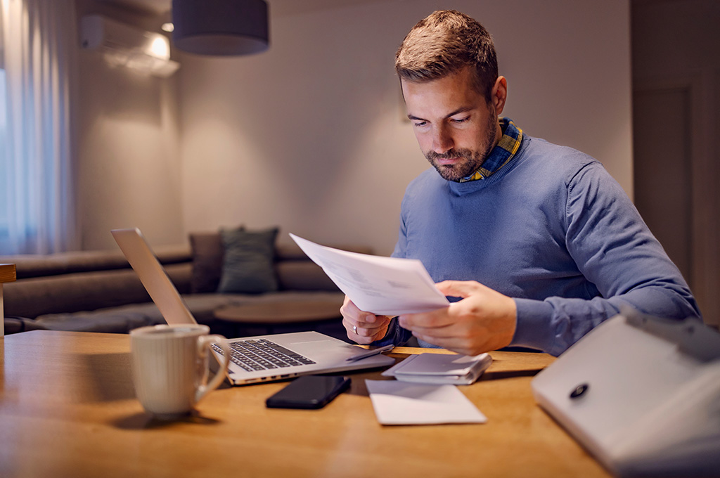A veteran at home going over his finances before exploring debt management options for veterans